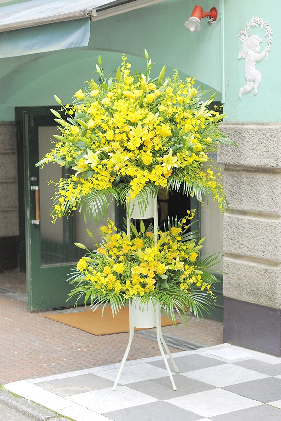温かみ溢れる黄色系で統一したスタンド花二段タイプです。